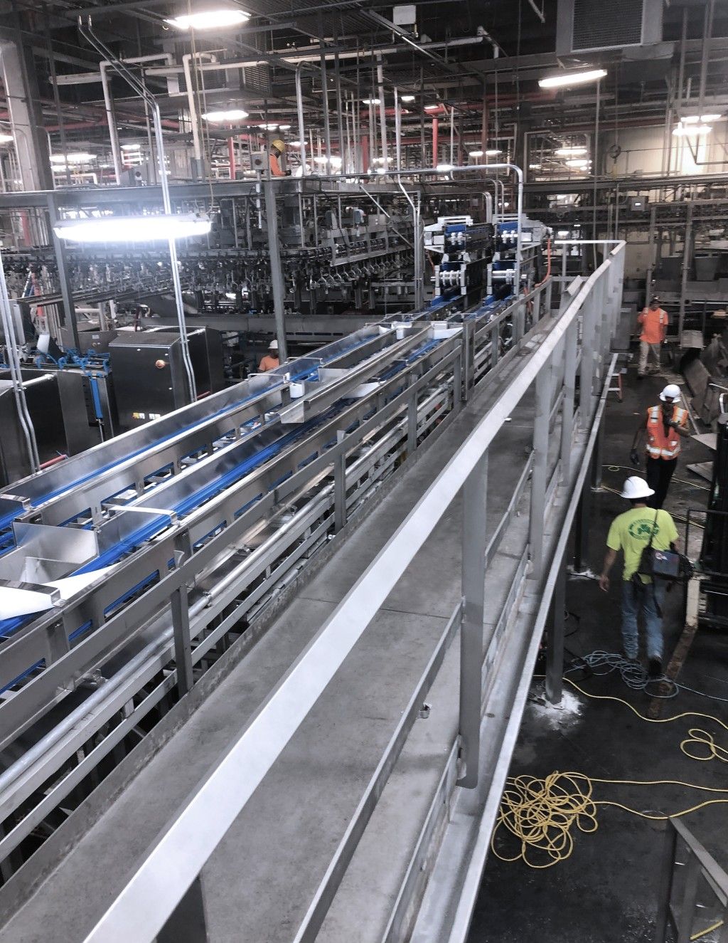 ProFab engineers installing conveyors in a large food processing facility